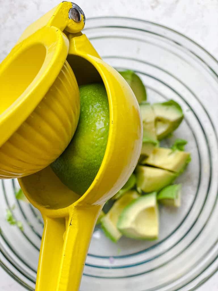 process shot of juicing lime onto avocados