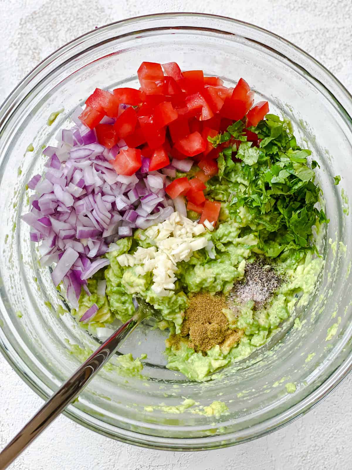 ingredients for easy guacamole in glass bowl prior to being mixed