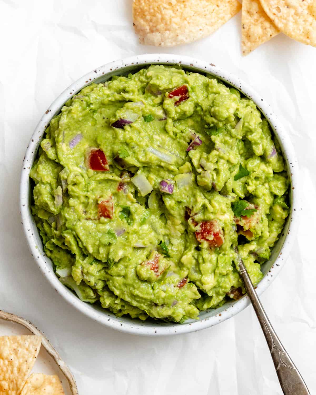 Completed Easy Guacamole in a white bowl against a white background.