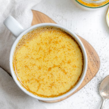 completed Turmeric Golden Milk [Haldi Doodh] in a white cup against a white background