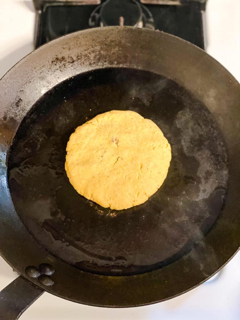 process shot of adding pupusas to pan