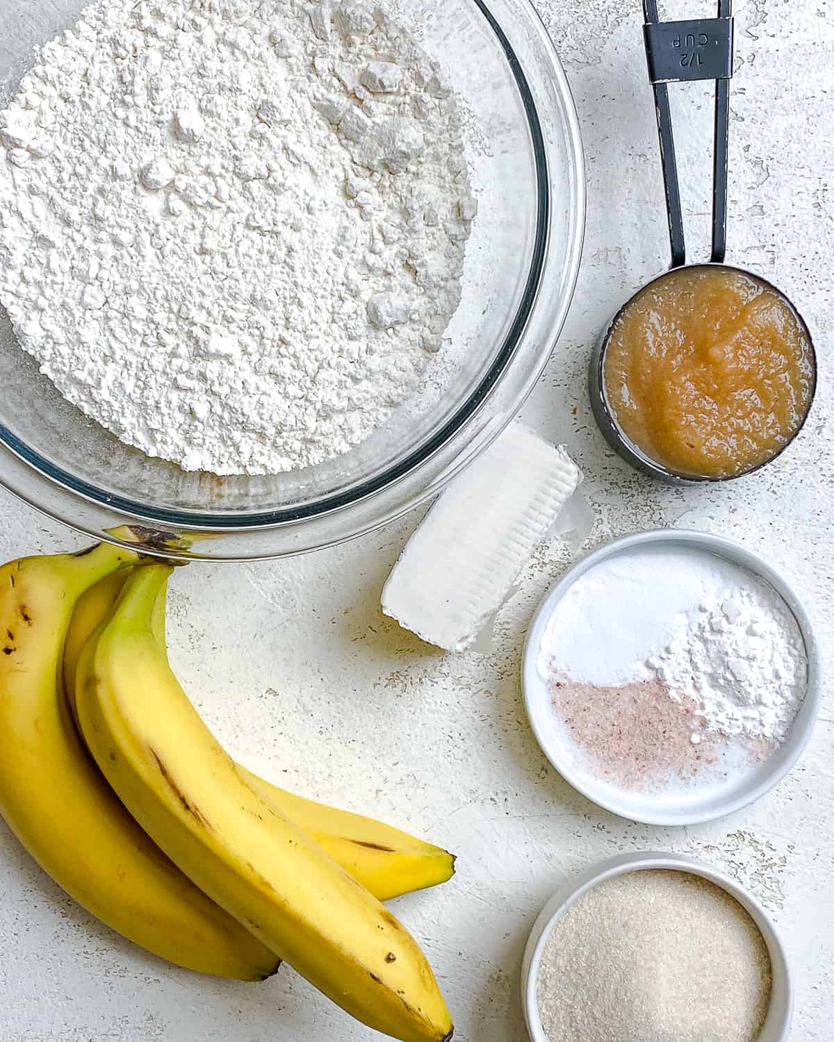 ingredients for Easy Vegan Banana Bread (With Applesauce) measured out against a white surface