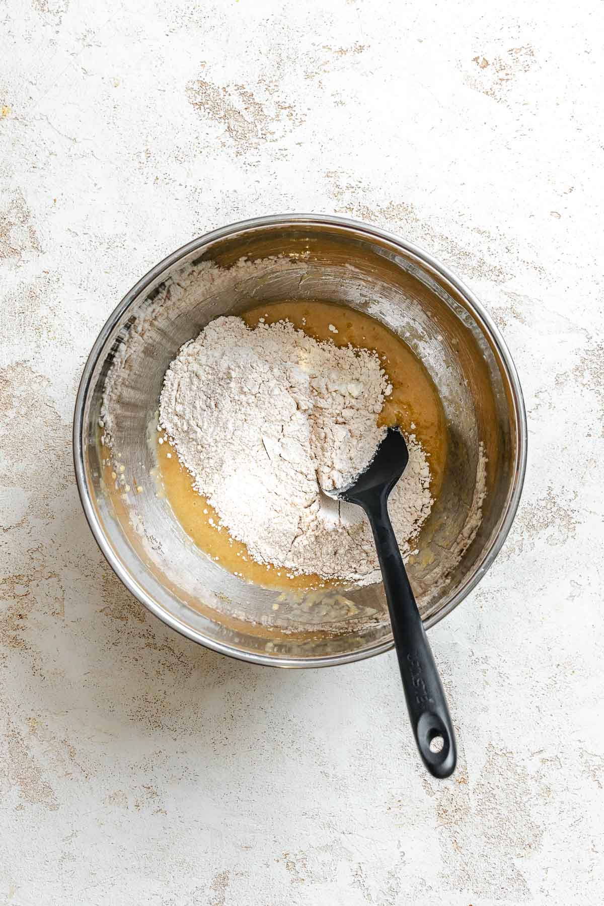 Process shot showing mixing ingredients together in a bowl.