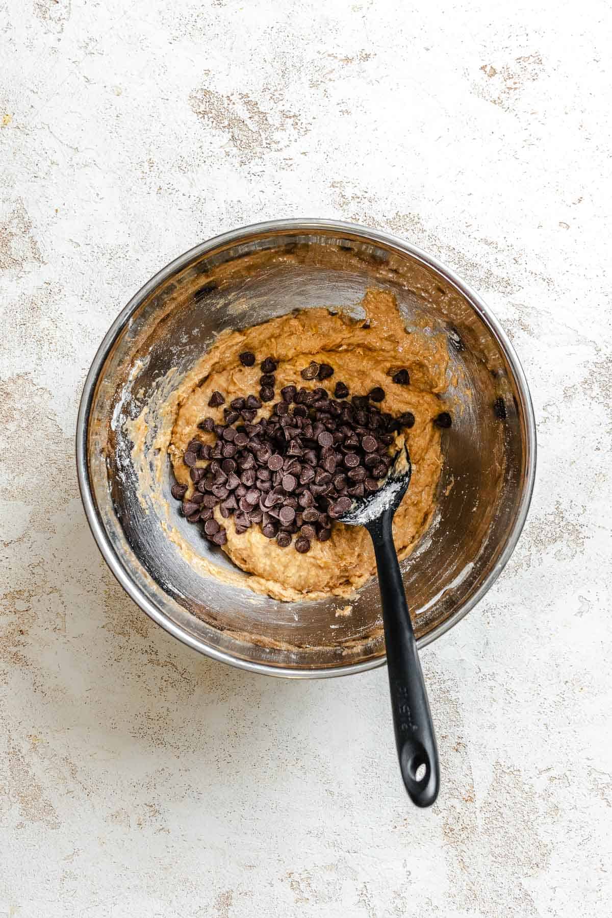 Process shots showing adding vegan chocolate chips into bowl.