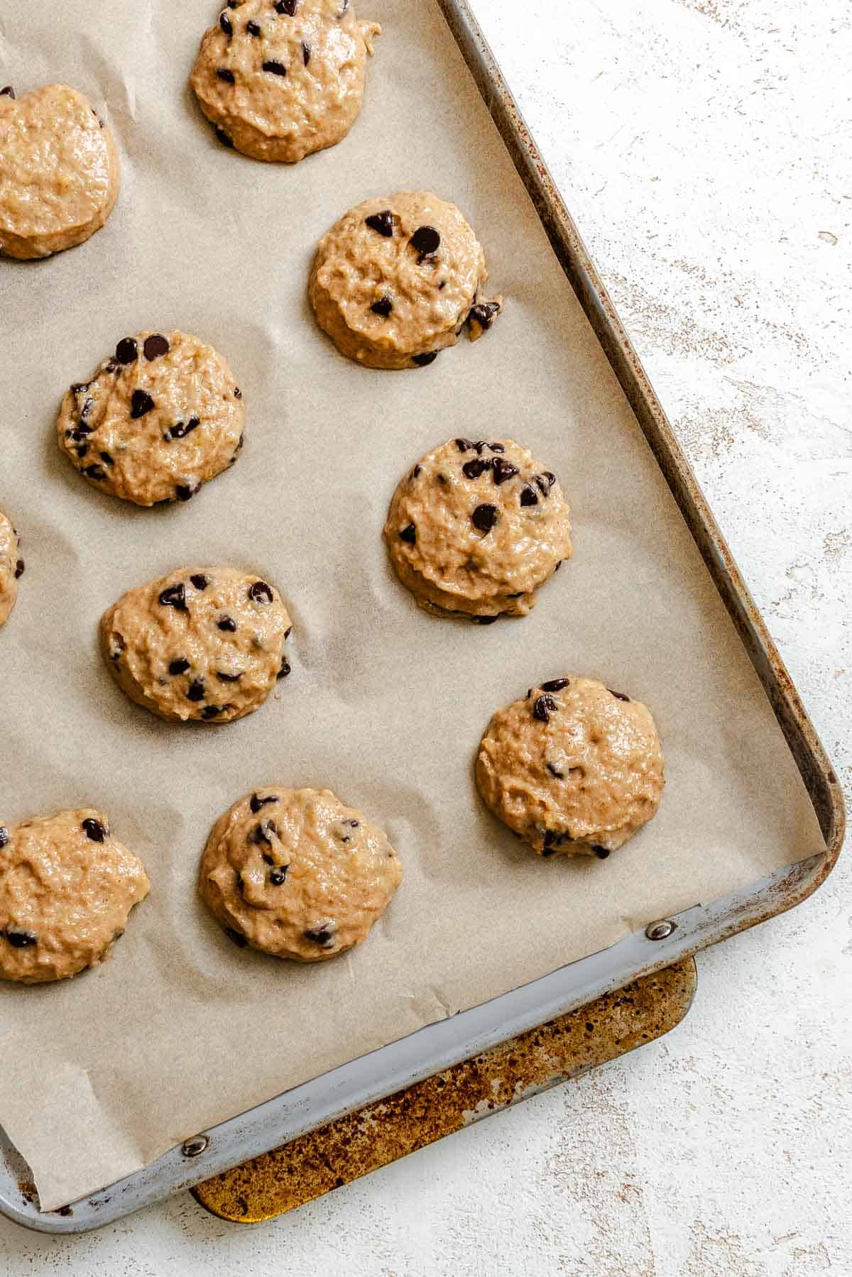 Process shot showing cookies added to baking sheet.