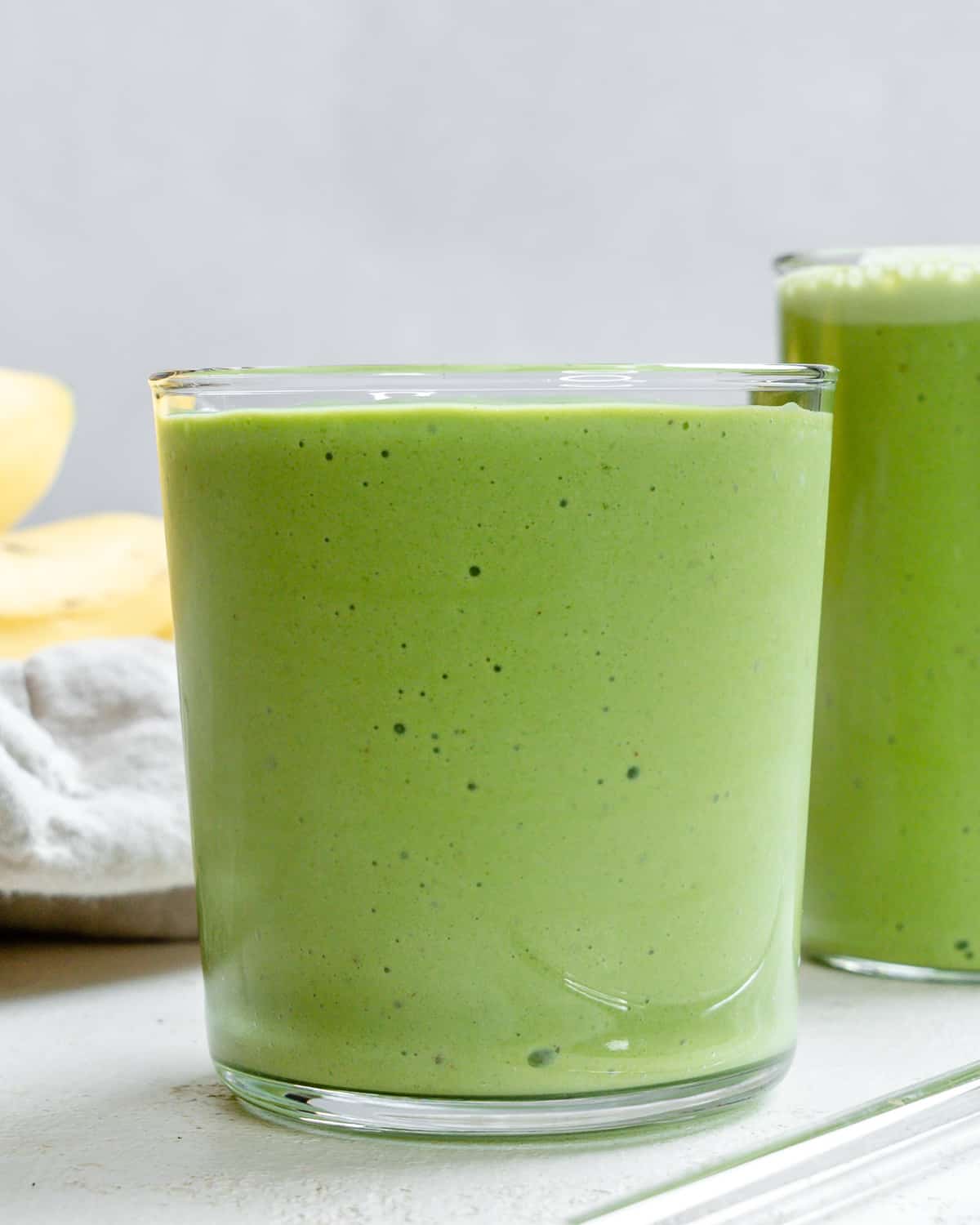 ready-made banana and kale smoothie in two glasses 