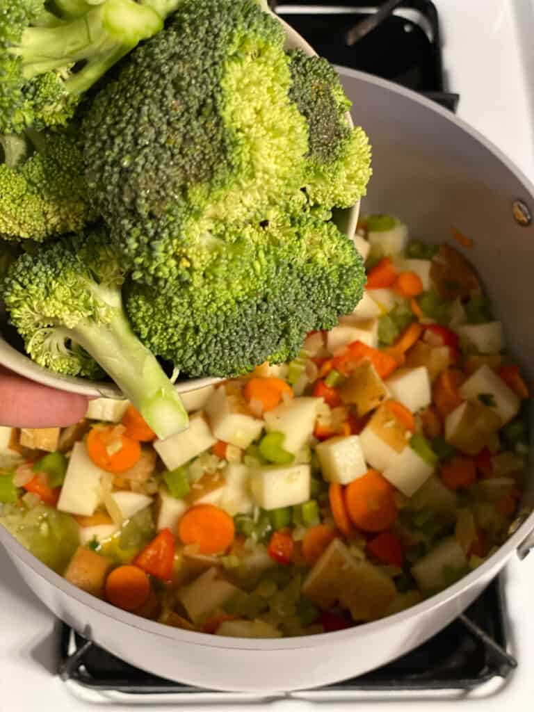 process shot of broccoli being added to pot
