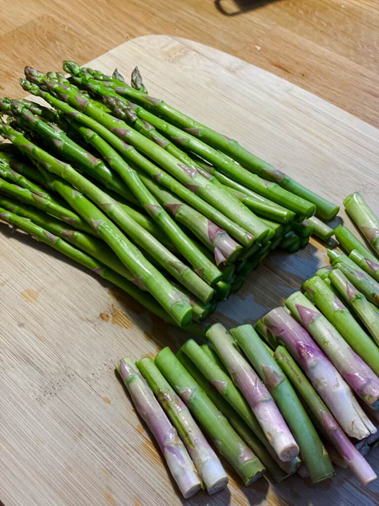 Process shot of cutting asparagus on a cutting board