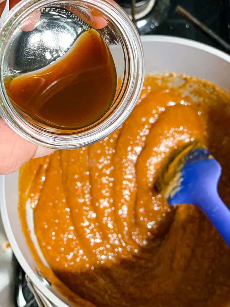 Prozessaufnahme des Hinzufügens von Vanilleextrakt zur Erdnussbuttermischung