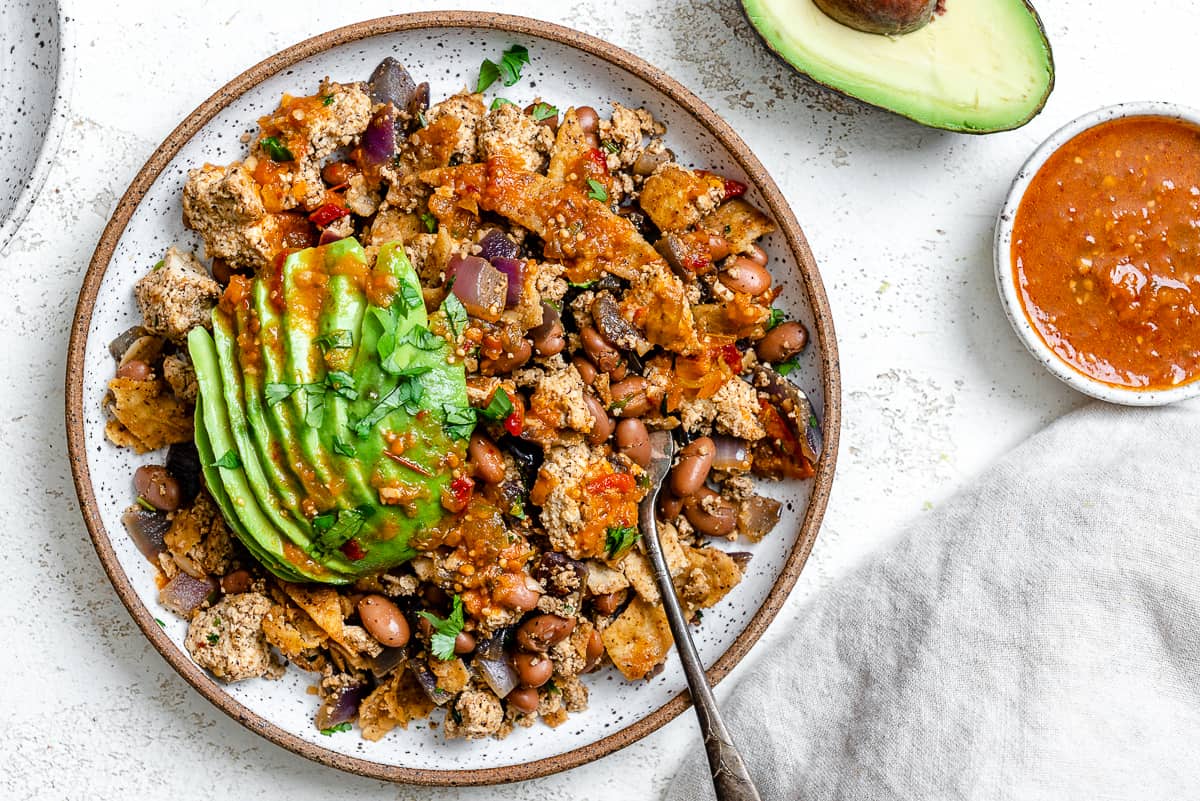 completed Vegan Chilaquiles [Rojos or Verdes] plated on a plate against a white background