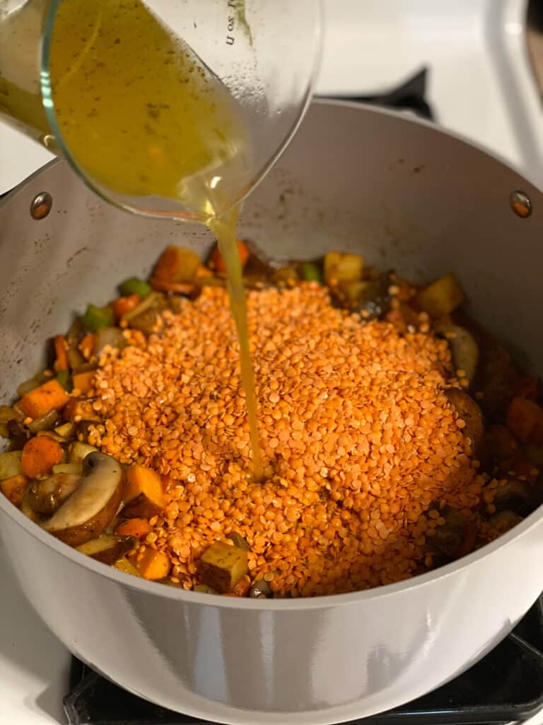 process shot of adding veggie broth to pot