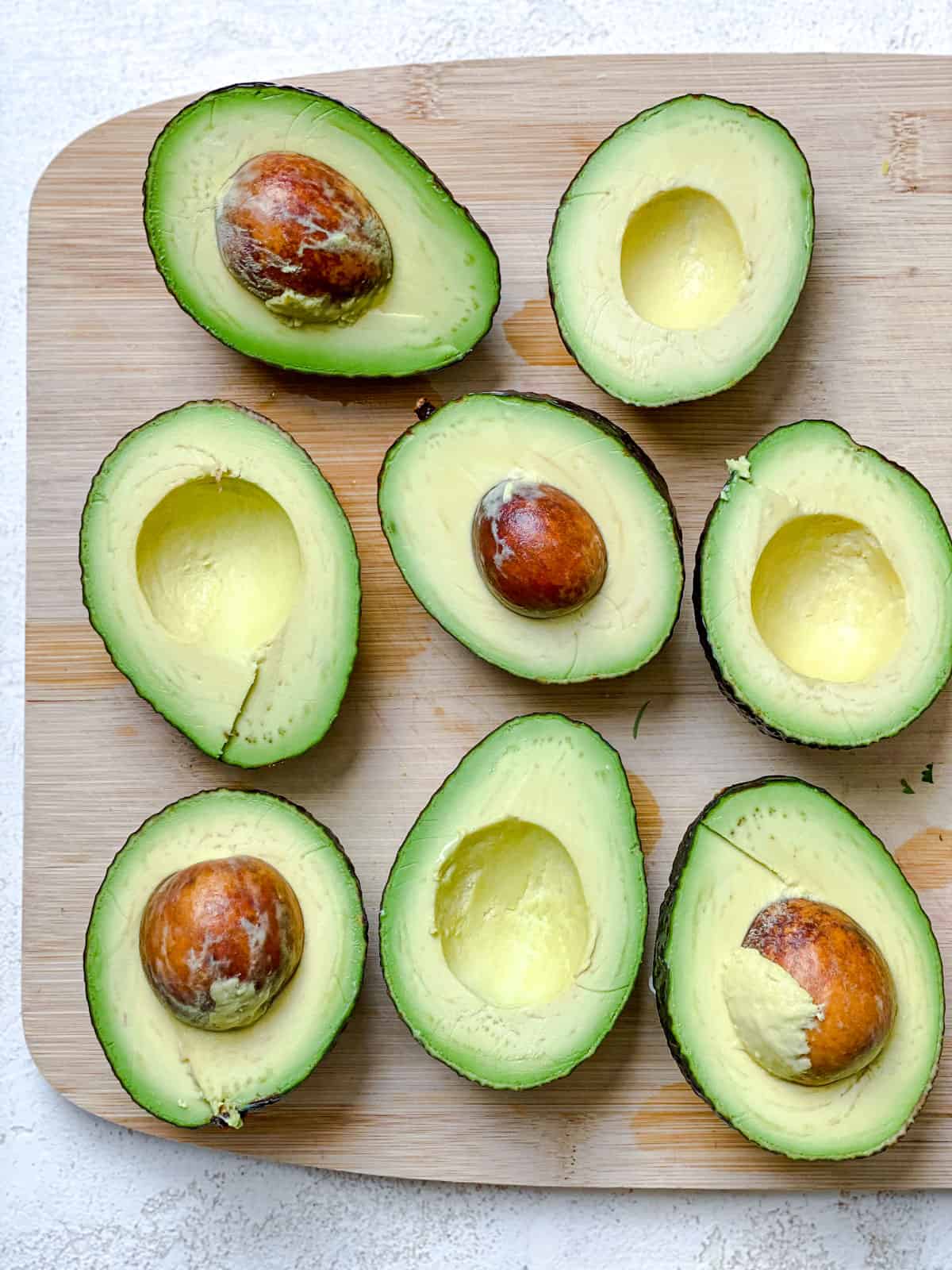 halved avocados against a cutting board
