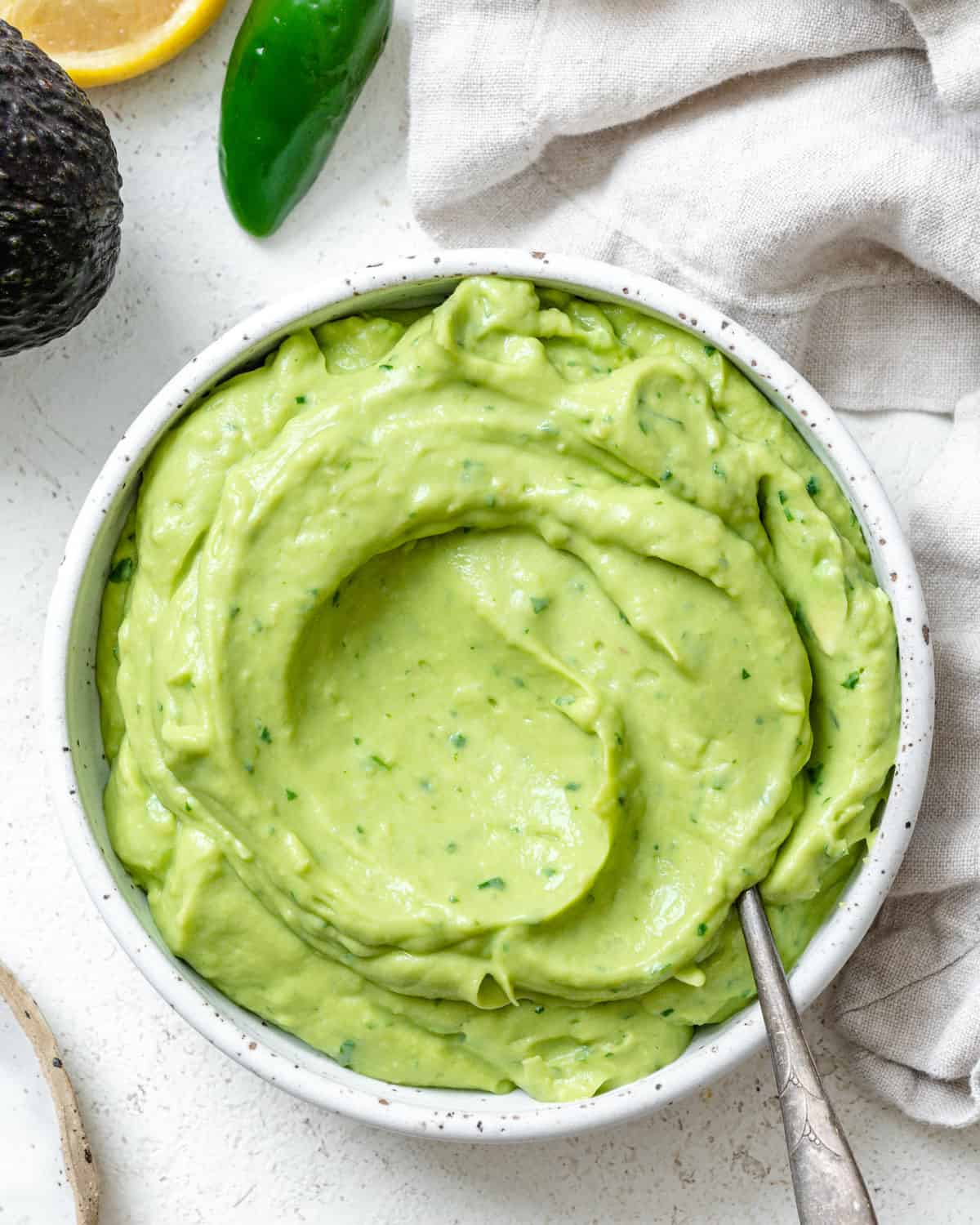 completed Mexican Avocado Crema  in a white bowl against a white background