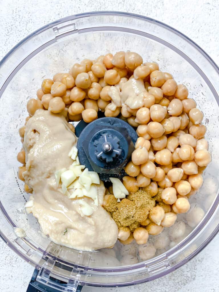 process shot of adding Easy Hummus ingredients to food processor