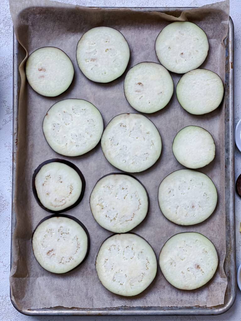 process shot of eggplant slices added to baking tray