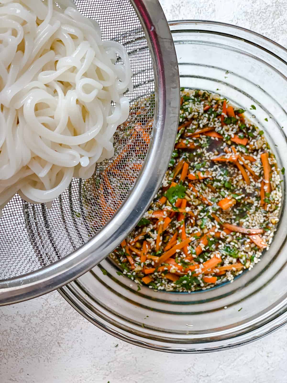 process shot of adding noodles to glass bowl