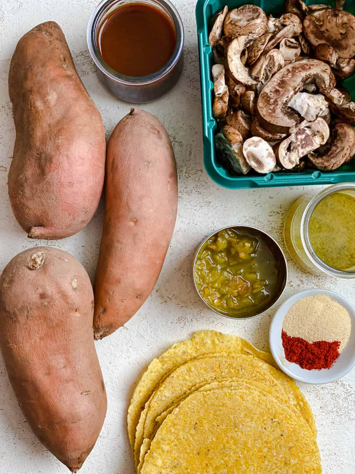 Ingredients for sweet potato enchiladas measured on a white surface