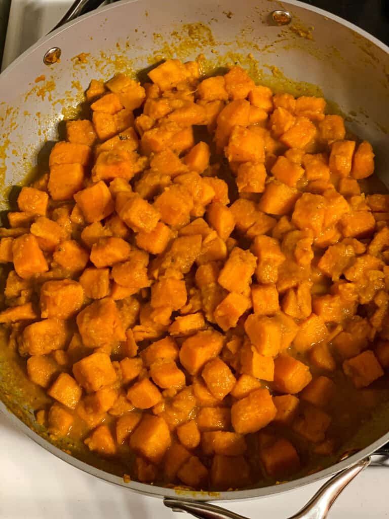 process shot of sweet potatoes cooking in a pan