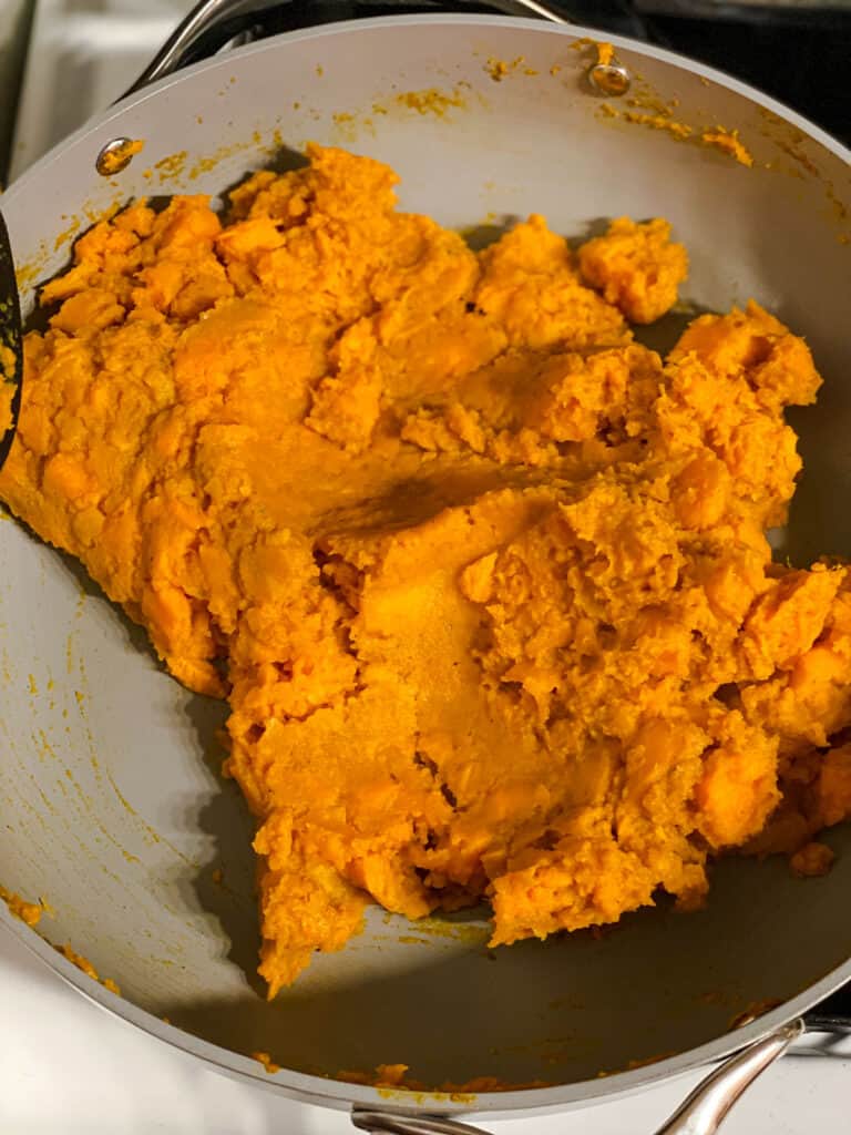 process shot showing softened and mashed sweet potatoes in pan