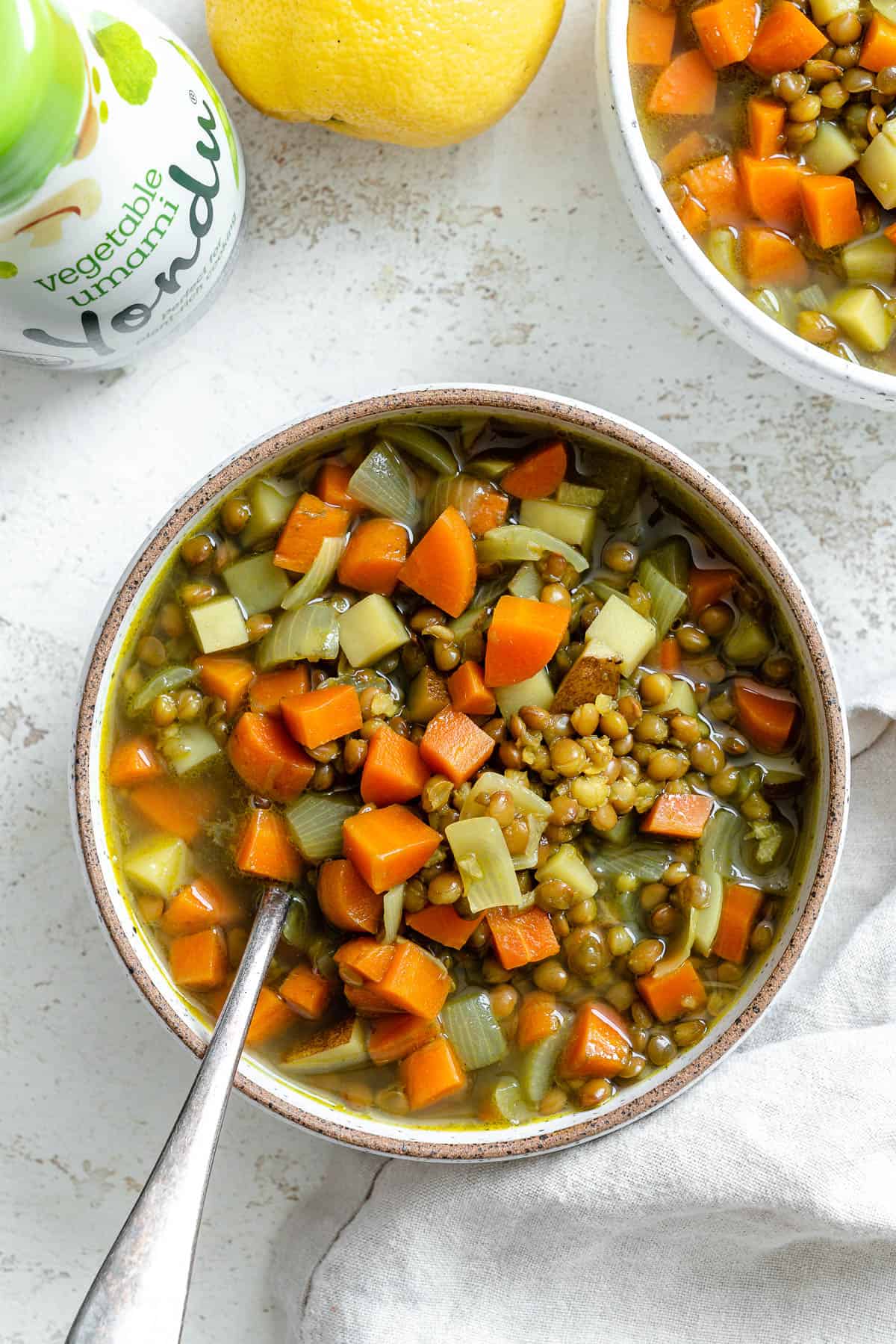 سوپ عدس و هویج را در یک کاسه در مقابل یک سطح سبک کامل کنید