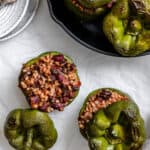 several completed stuffed bell peppers on white surface and pan
