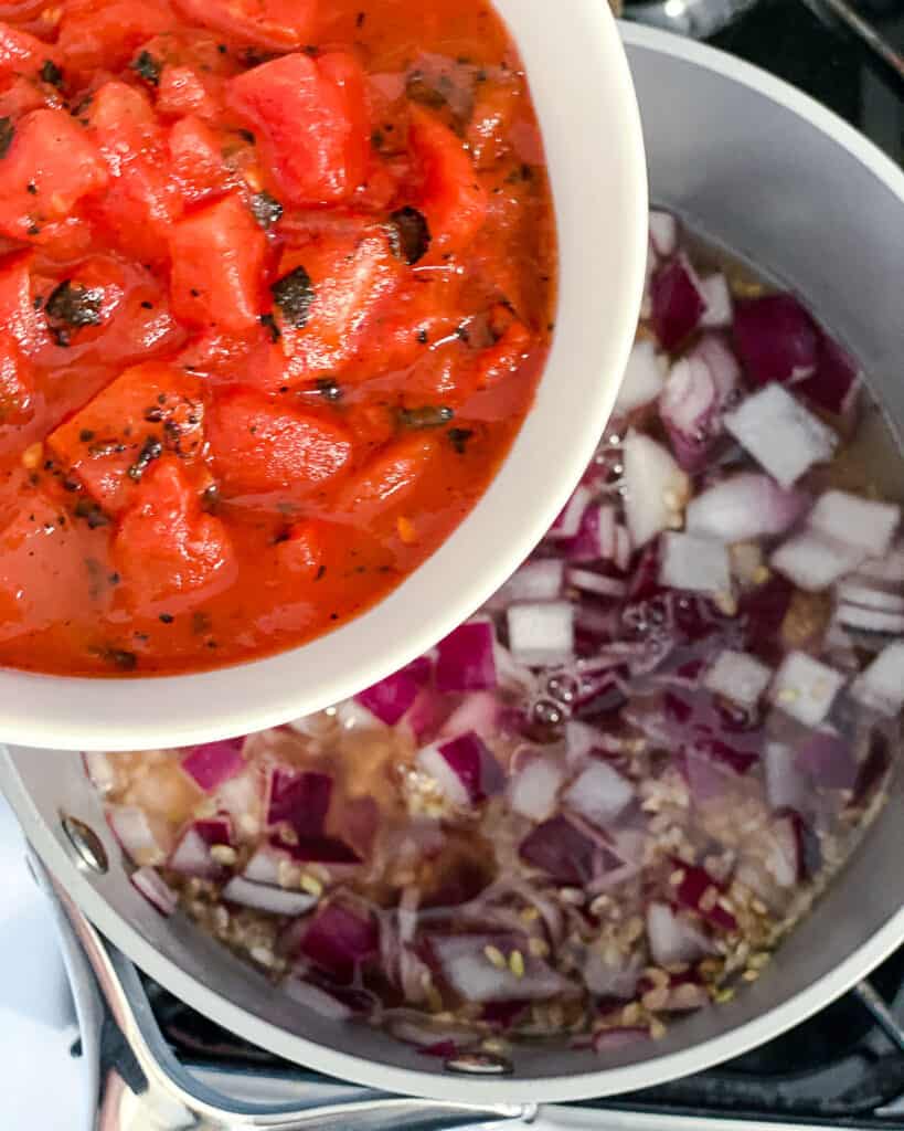 process shot of adding tomatoes to bowl of ingredients