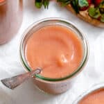 completed Easy Strawberry Apple Sauce in a cup with a spoon against a white background