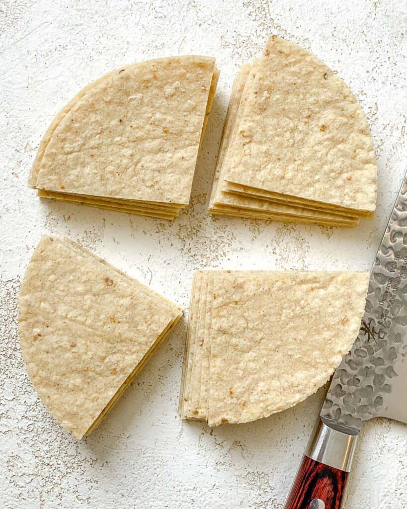corn tortilla sliced into quarters against a white surface