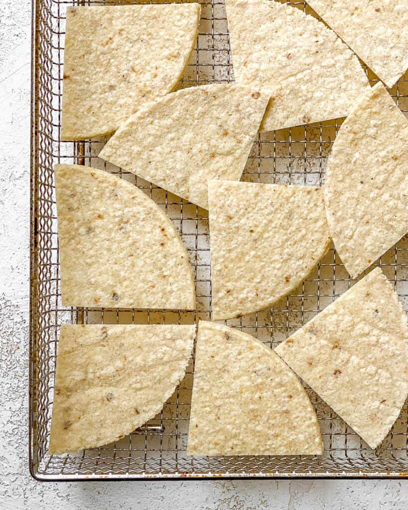 tortilla pieces spread out on air fryer tray