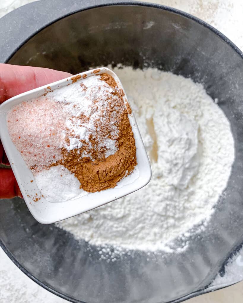 process shot of adding additional powders and spices to bowl of flour