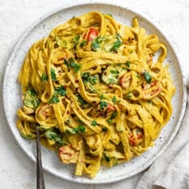 completed Creamy Curry Pasta (Vegan) plated on a white plate against a white surface