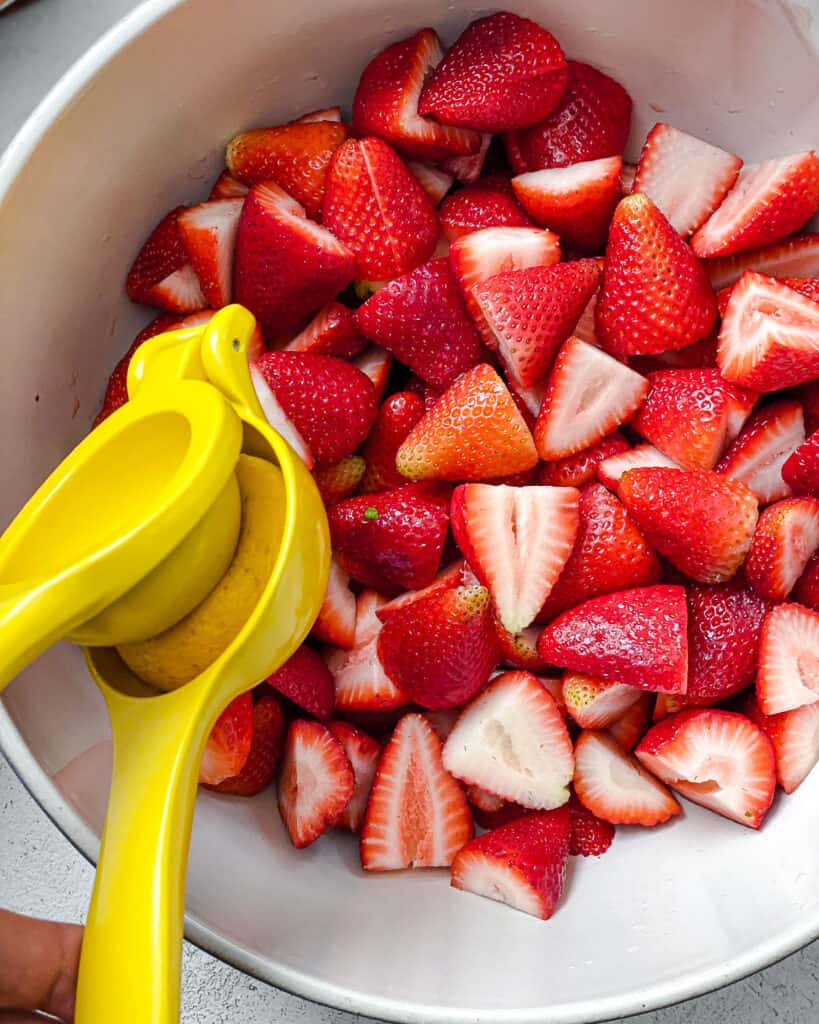 process shot of juicing lemon over strawberries
