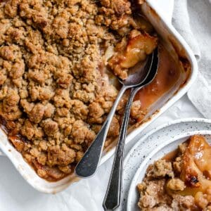 completed Vegan Apple Crumble with a piece missing in a baking dish