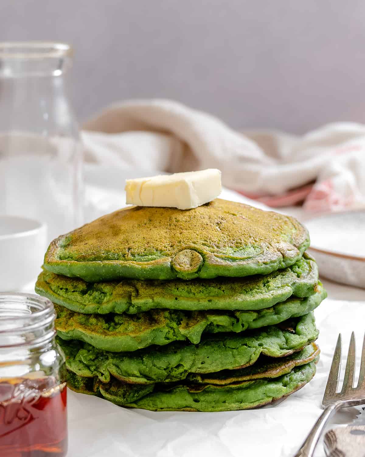 completed stack of Easy Banana Spinach Pancakes against a light surface