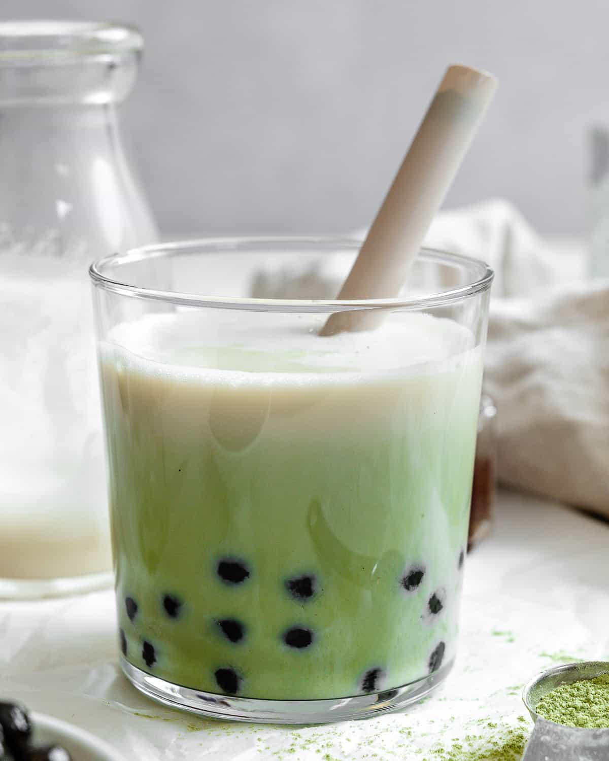 completed Matcha Boba Tea (Green Milk Tea) in a glass against a light background