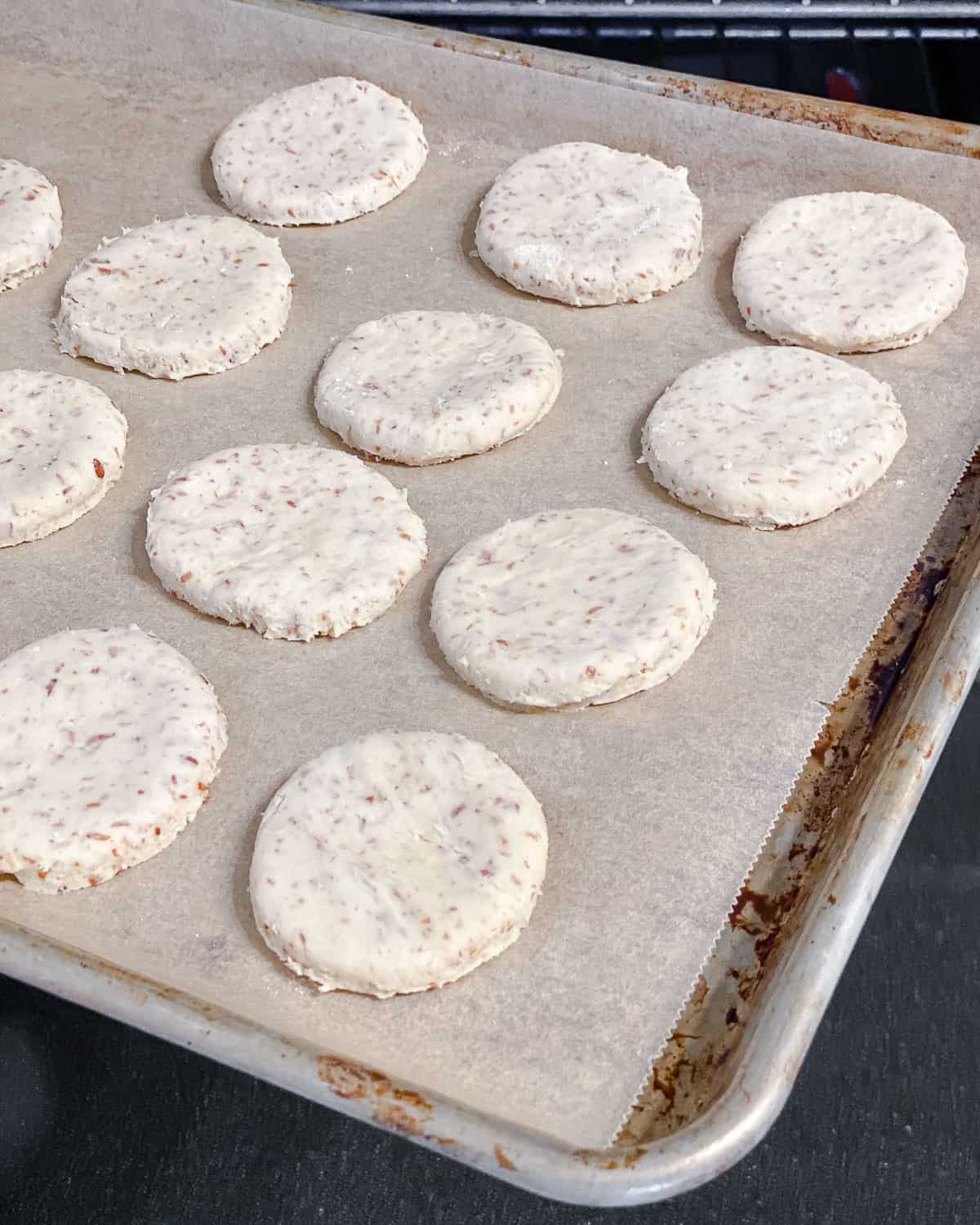 process shot of cookie dough circles on a baking sheet