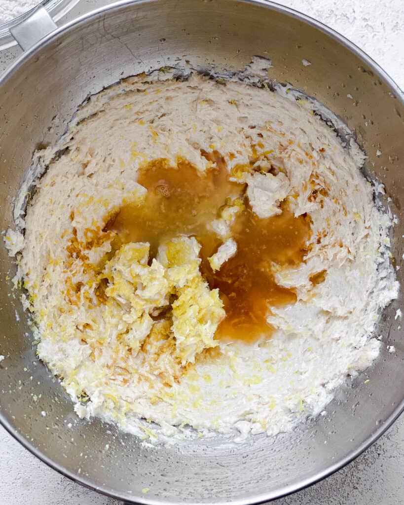 process shot of adding additional ingredients to bowl of sugar and butter