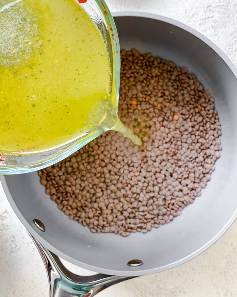 process shot of adding lemon mixture to lentils in bowl