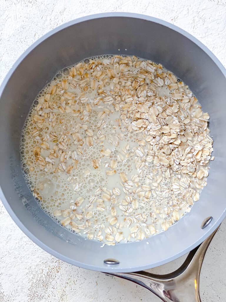 process shot of adding oats and plant-based milk in a pot