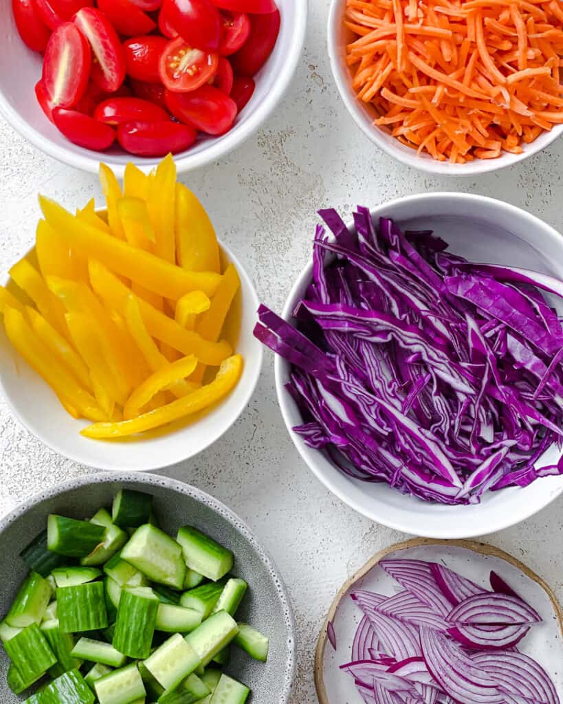 ingredients measured out for rainbow salad in individual bowls