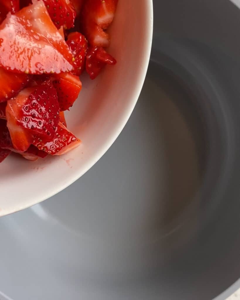 process shot of pouring strawberries into bowl