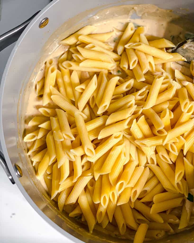 process shot of mixing pasta into the pan
