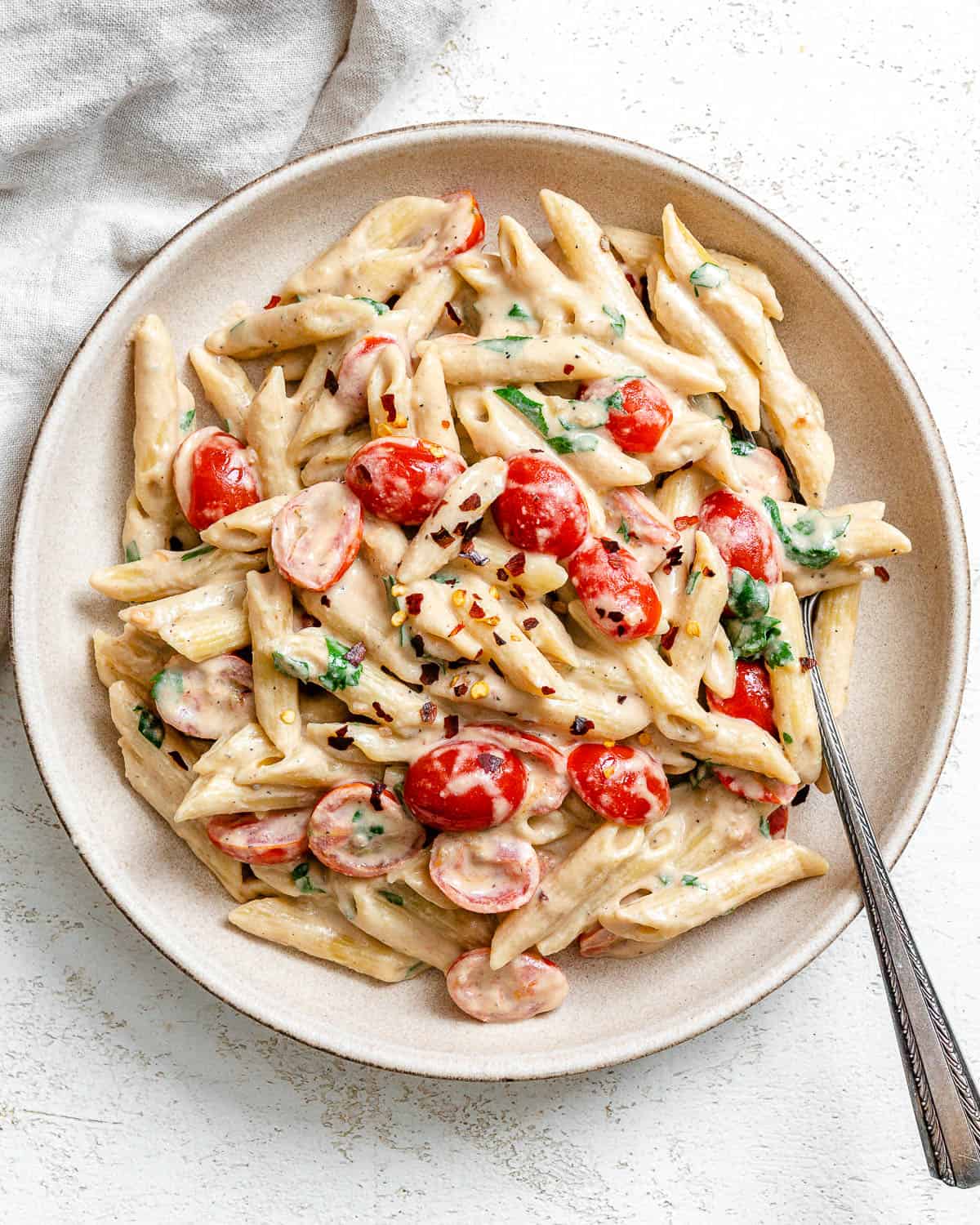 completed 20-Minute Creamy Tahini Pasta plated on a white plate against a light surface