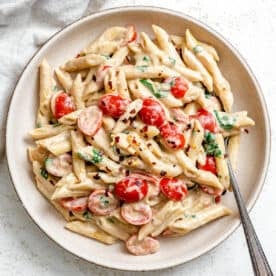 completed 20-Minute Creamy Tahini Pasta plated on a white plate against a light surface
