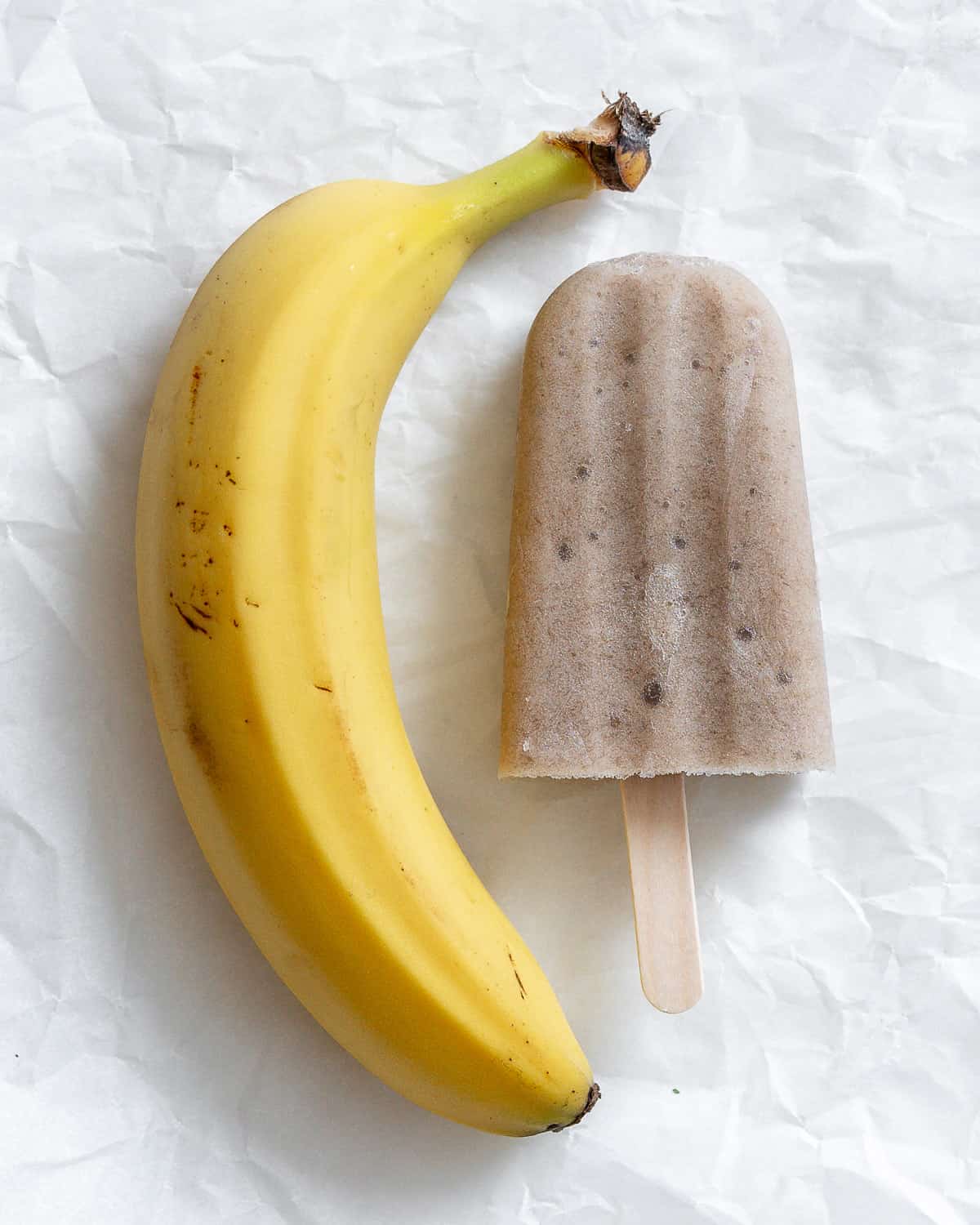 banana and banana popsicle on a white surface