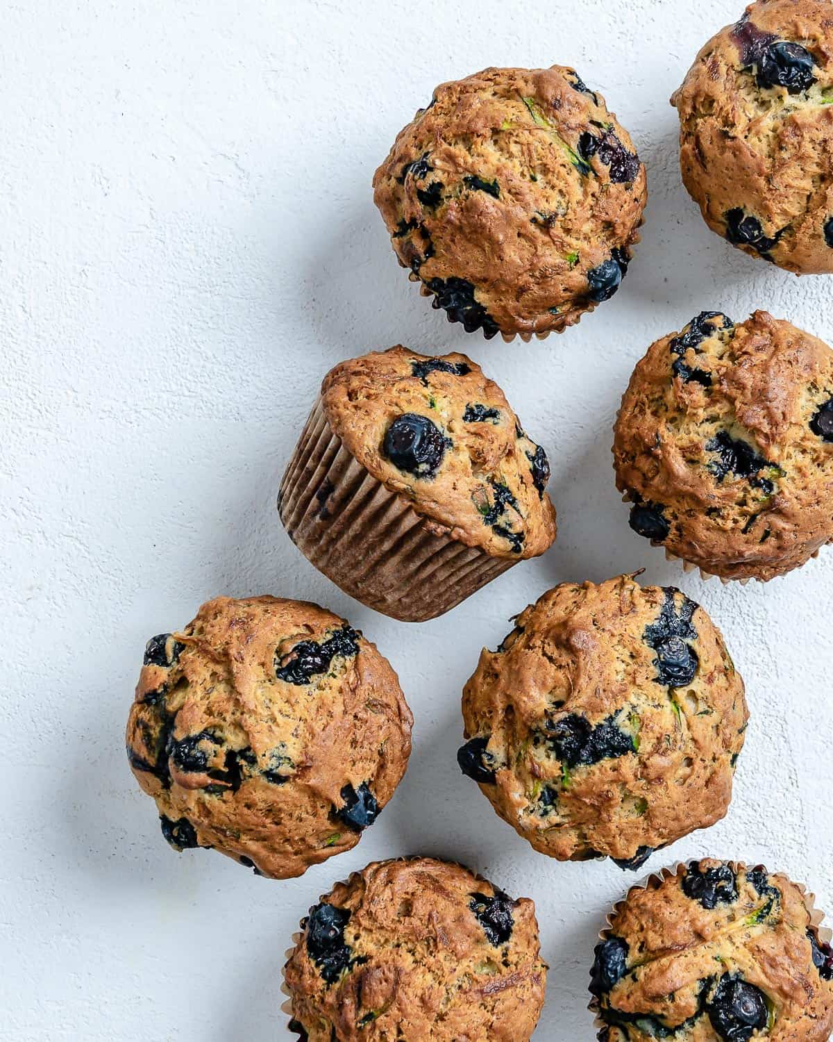 post cooked Blueberry Zucchini Muffins against a white background