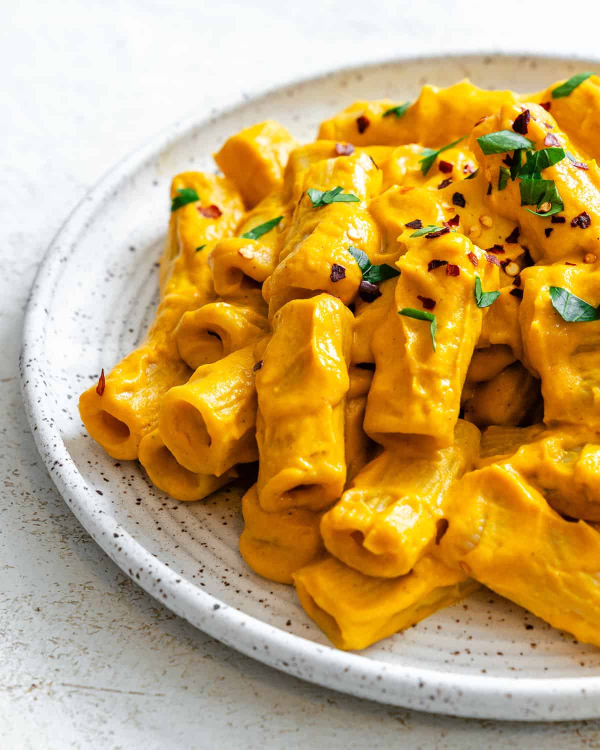 completed and plated Easy Carrot Pasta Sauce against a white surface