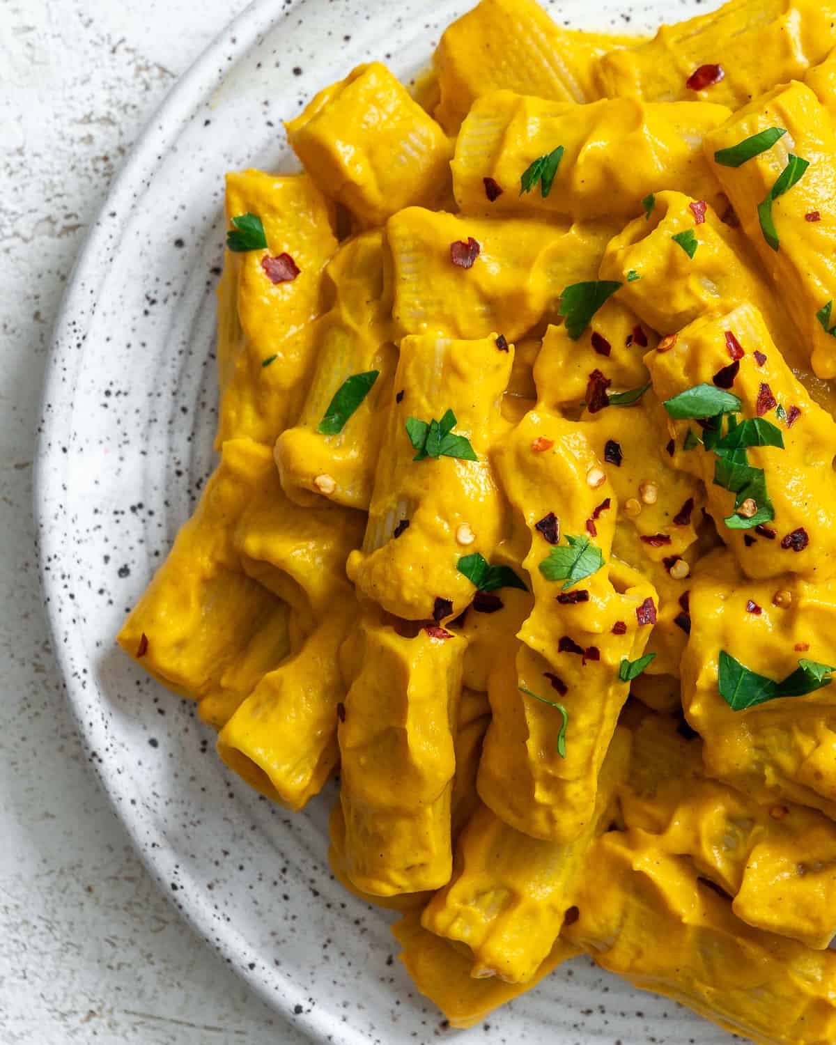 completed and plated Easy Carrot Pasta Sauce against a white surface