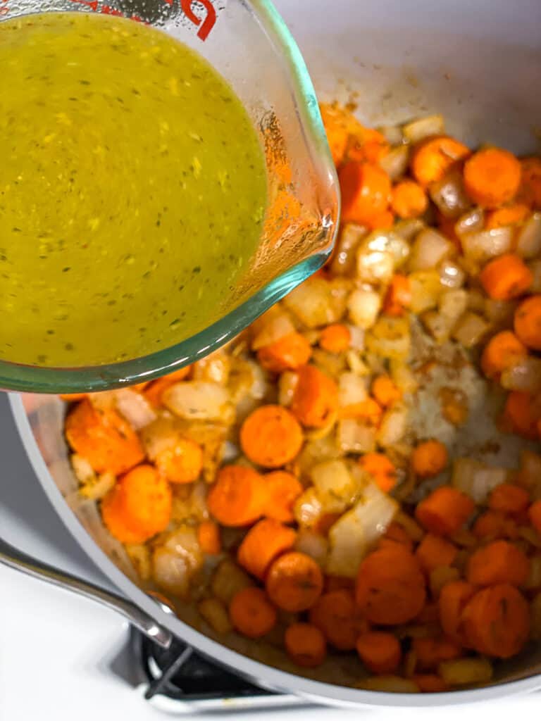 process shot of adding veggie broth to pan