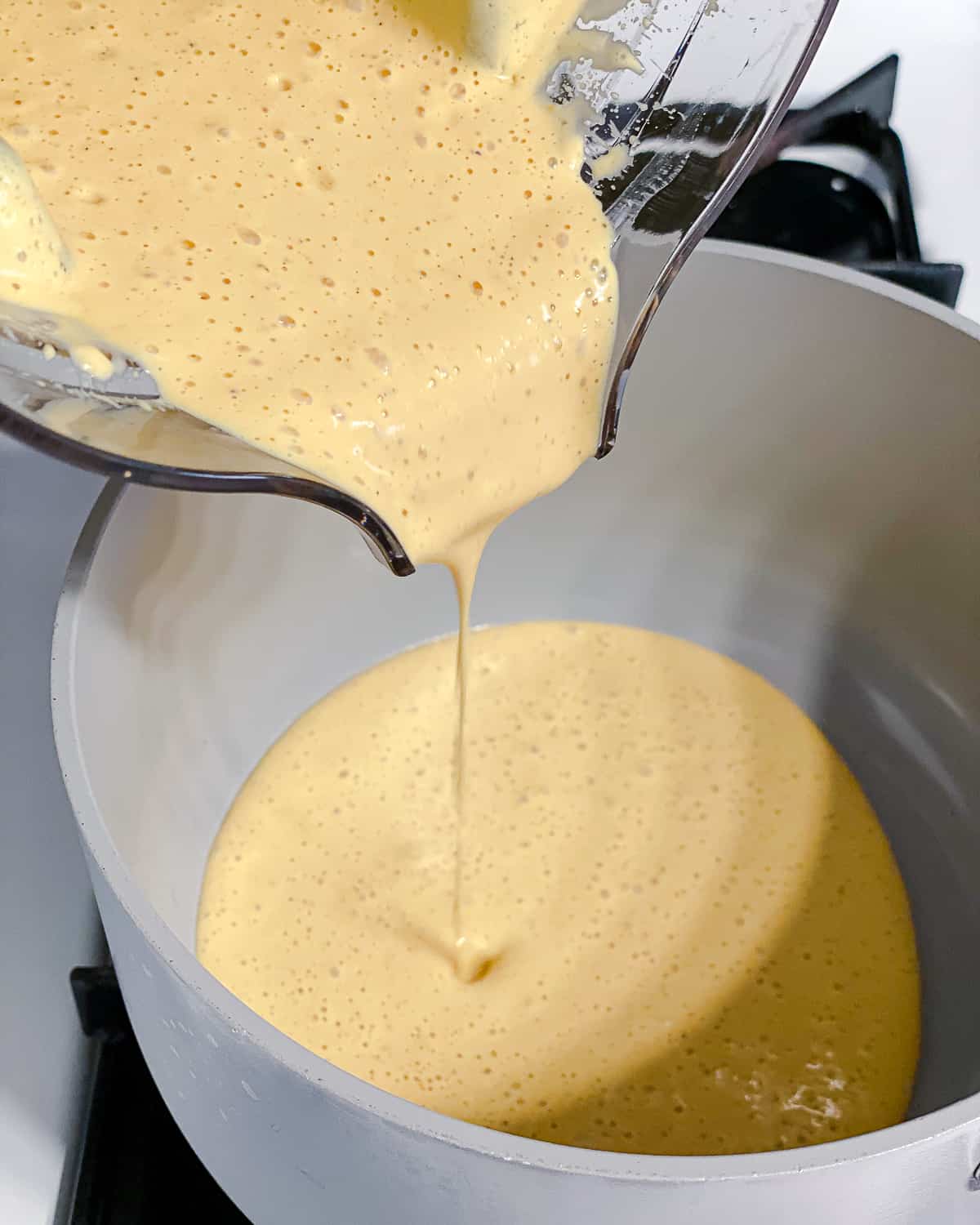 process shot of adding blended ingredients to pot